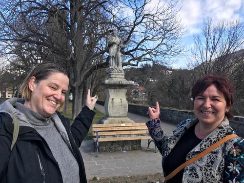 Schriftstellerin Heidi Troi (links) und Illustratorin Evi Gasser besuchen die berühmte Nepomuk-Statue in den Brixener Rappanlagen.